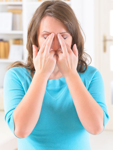 Woman doing EFT on the eye brow point. Emotional Freedom Techniques, tapping, a form of counseling intervention that draws on various theories of alternative medicine.